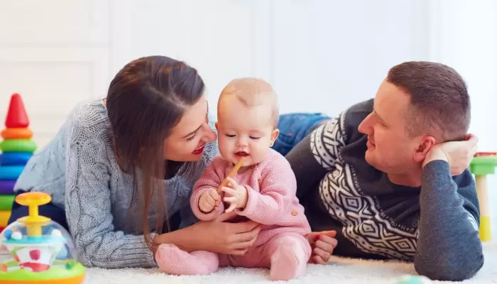 mother and father playing with infant baby girl