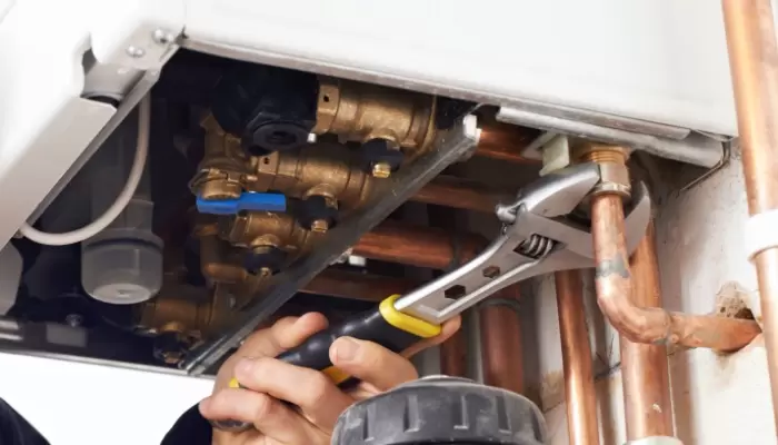 plumber working on central heating boiler